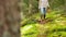 Woman with mushrooms in basket walking in forest