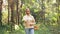 Woman with mushrooms calling on cellphone in woods