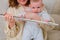 Woman musician with infant baby teaches music and shows the flute