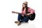 Woman musician playing guitar sitting on floor.