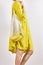 Woman in mustaed linen dress holding mash bag with bananas. Sustainable zero wast lifestyle concept