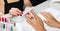 Woman nail technician performing professional manicure for young female client