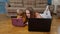 Woman nanny and child girl studying together with computer laptop, while lying on warm floor at home