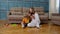 Woman nanny and child girl studying together with mobile phone and tablet, sitting on floor at home