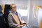 Woman napping on seat while traveling by airplane.