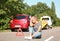 Woman near broken car and tow truck