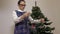 Woman near Christmas tree with Christmas lights