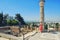 A woman near the great marble column of Carthage. Tourists at the Museum excavations of the ancient city in Tunisia