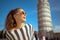 Woman near leaning tower in Pisa, Italy looking into distance