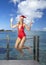 The woman in New Year\'s Santa-Klaus cap on background of sea jumps