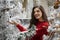 Woman next to snowy Christmas tree, store filled with ornaments