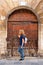 Woman next to a very old wooden door in the medieval village of Salvatierra, Spain.