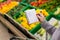 Woman with notebook in grocery store, closeup. Shopping list on paper.