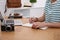 Woman with notebook planning trip at wooden table, closeup