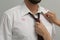 Woman noticed lipstick kiss marks while straightening her husband`s shirt and necktie, closeup