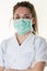 Woman nurse arms crossed with protective face mask COVID-19 coronavirus epidemic