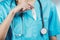 Woman nurse or doctor close up while she is putting a thermometer inside her chest pocket