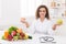 Woman nutritionist holding fruit and croissant in hands