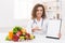 Woman nutritionist pointing on blank clipboard at office