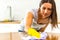 Woman with obsessive compulsive disorder cleaning kitchen with detergents, but everything is clean anyway.