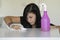 Woman with obsessive compulsive disorder cleaning table with detergents. OCD concept