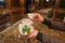 Woman offering steak tartare with froth and Caprese salad