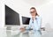 Woman in office at desk in front of computer