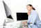 Woman in office at desk in front of computer, mouse click