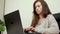 A woman in the office works on a modern computer. Business woman typing text on laptop keyboard. Female hands of a