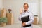 Woman with Okay Sign in Empty Room with Packed Moving Boxes