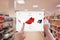 Woman online shopping with tablet. Holding device and choose red shoes