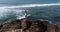 Woman open arms on cliff edge at seaside