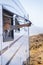 Woman opening caravan window in free parking outdoors admiring the nature outside. Travel and vehicle camper van destination for