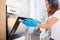 Woman Opening Door Of Oven Full Of Smoke