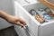 Woman opening drawer with warm socks, closeup