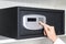 Woman opening steel safe with electronic lock