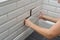 Woman opens, closes the hidden revision sanitary hatch on the wall of tile under the bathroom.