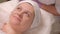 A woman opens her eyes after the procedure of cleansing the skin in the beauty salon. Health and beauty. Close-up.