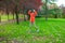 Woman in orange coat jumping in park