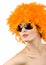 Woman with orange feather wig and sunglasses