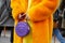 Woman with orange fur coat, yellow dress and purple bag with wifi symbol before Alberta Ferretti fashion show