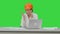 Woman in orange hardhat calling the phone discussing constraction plan on a Green Screen, Chroma Key.