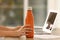 Woman with orange thermos bottle at workplace, closeup