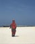 A woman in orange walks on the beaches of Zanzibar