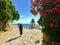 A woman and other tourists and locals walking around a pathway that goes around the old town of Rovinj, Croatia