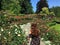 A woman and other visitors walking around admiring a beautiful rose garden  at Butchart Gardens