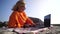 Woman outdoor laptop. Business woman in orange outfit, freelancer with laptop working on mountain top. Happy smiling