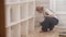 Woman in overalls sitting in a corner causes paint brush on the floor