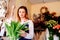 Woman owner of florist shop preparing bouquet of pink tulips.