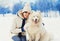 Woman owner hugging white Samoyed dog on snow in winter